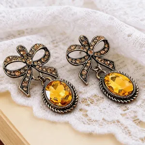 Detailansicht der Vintage-Ohrringe mit Schleifen-Design und gelben Kristallen im Gold-Look