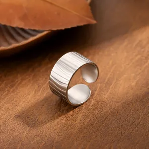 Breiter offener Edelstahlring mit strukturierter Blattoptik, minimalistischer Stil.