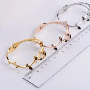 Detailed shot of gold, rose gold and silver leaf bangles with a size ruler