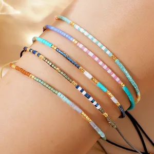 Detailed macro view of colorful seed bead bracelets with gold accents and adjustable cords