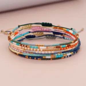 Close-up detail of colorful Miyuki seed bead bracelets with adjustable cord and gold beads