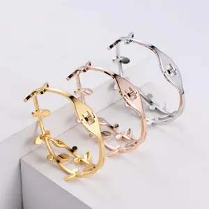 A detailed close-up of olive leaf branch bracelets in gold, rose gold and silver
