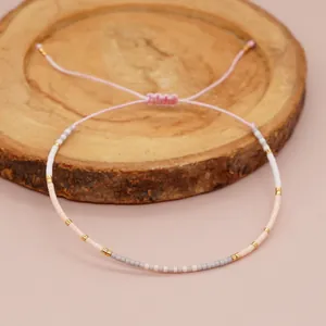 Detailed view of handmade minimalist seed bead bracelet with adjustable cord