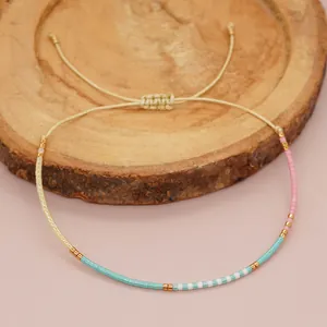Detail view of adjustable beaded bracelet with blue pink and gold accents.