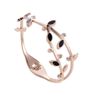 Elegant rose gold leaf branch bangle with black enamel accents and sparkling rhinestones.