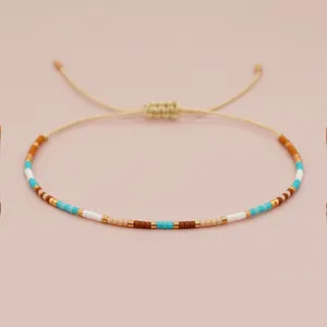 Close-up view of adjustable handmade seed bead bracelet with gold accents.