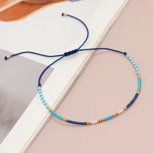 Close-up detail of a handmade colorful seed bead bracelet with an adjustable blue woven cord