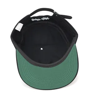 Vista interna dettagliata di un cappello hip-hop nero con visiera verde ed etichetta