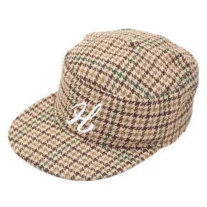 Dettaglio del cappello militare pied de poule con lettera H ricamata in bianco