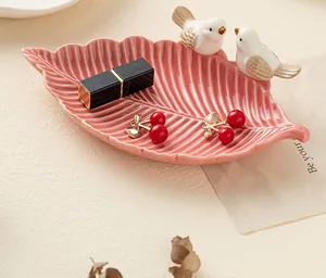 Dettaglio del vassoio per gioielli in ceramica a foglia rosa con figurine di uccellini