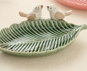 Dettaglio del vassoio per gioielli in ceramica a forma di foglia con due uccellini