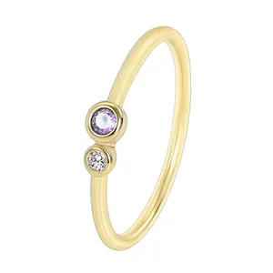 Detailansicht eines minimalistischen Goldrings mit violetten und klaren Zirkonsteinen