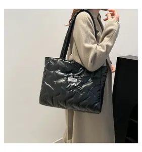 Fashionable black quilted puffer tote bag for women shown as a shoulder bag detail