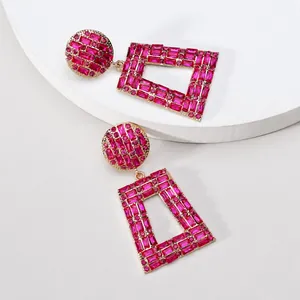 Detailaufnahme von geometrischen Trapez-Ohrringen mit leuchtend rosa Strasssteinen