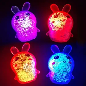 Nahaufnahme von vier leuchtenden Hasen-Antistress-Spielzeugen mit farbigen LED-Lichtern