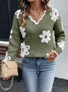 Primo piano di maglione verde scollo a V con fiori jacquard bianchi
