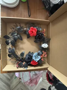 Vue détaillée d'une couronne d'Halloween avec crâne et roses dans une boîte en carton