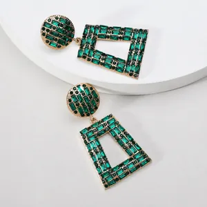 Detailaufnahme smaragdgrüner geometrischer Strassohrringe mit Vintage-Gold-Finish-Look.