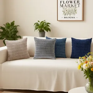 Set of quilted plush pillow covers in grey and blue tones displayed on a cozy sofa