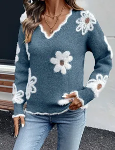 Vista ravvicinata di un maglione blu con scollo a V e eleganti motivi floreali jacquard.