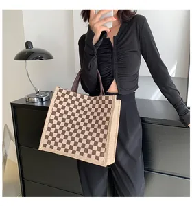 Sac cabas élégant en jute à carreaux porté par un mannequin, décor moderne