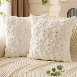 Close-up detail of white plush cushion covers featuring 3D quilted floral embroidery pattern