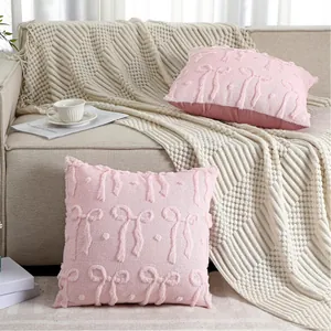 Detail showing soft pink quilted plush pillowcase with bow patterns on a sofa