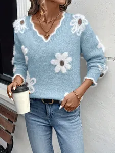 Dettaglio di un maglione in maglia azzurro con scollo a V e motivi floreali jacquard