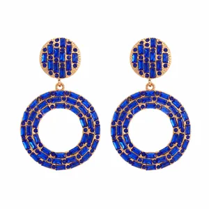 Makroansicht von Vintage-Ohrringen in Gold mit strahlend blauen geometrischen Kristallen