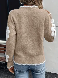 Vista posteriore di un elegante maglione di maglia marrone con fiori di peluche bianchi