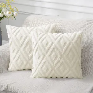 Detailed macro shot of cream faux fur pillow cover with geometric diamond quilted pattern