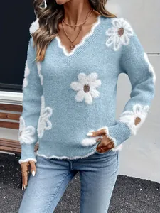 Dettaglio ravvicinato di un maglione blu chiaro con scollo a V e jacquard floreale