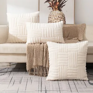 Detailed view of white plush quilted pillow covers with geometric texture on a sofa