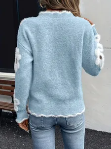 Vista posteriore di un elegante maglione in maglia azzurro con fiori bianchi soffici