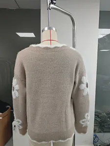 Vista posteriore di maglione in maglia beige con jacquard floreale bianco e bordi soffici