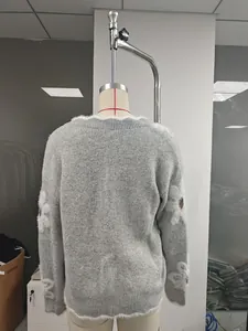 Vista posteriore di maglione grigio lavorato a maglia con fiori bianchi in finta pelliccia