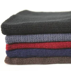 Stack of warm knitted winter beanies in multiple colors for outdoor skiing and hiking.