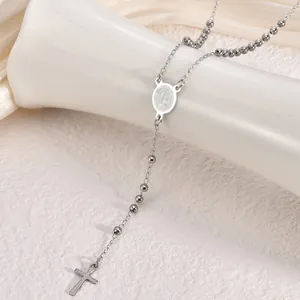 Close-up detail of stainless steel rosary necklace with Virgin Mary medal and cross