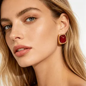 Close-up of a model wearing red sugar-cube earrings with gold-plated stainless steel