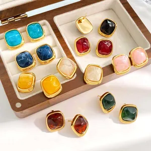 Detailed view of colorful square sugar-shaped stud earrings in a wooden jewelry box