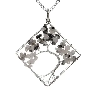 Detailed macro view of handmade wire-wrapped tree of life pendant with grey stones