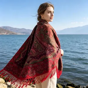 Detailansicht eines ethnischen Vintage-Schals mit Paisley-Muster und roten Fransen