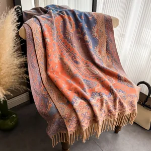 Nahaufnahme eines dicken Ethno-Schals mit Paisley-Muster und eleganten beigen Fransen