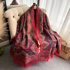 Makro-Detail eines ethnischen Paisley-Schals mit Quasten auf einem Stuhl