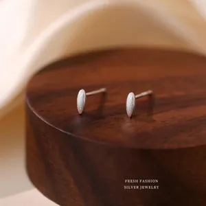 Detailed macro shot of minimalist S925 sterling silver textured olive shaped stud earrings