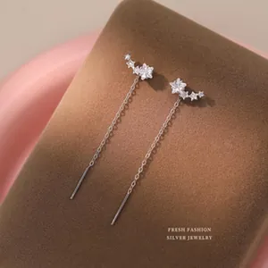 Detailed macro shot of elegant silver star-shaped cubic zirconia threader drop earrings