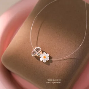 Detailed close-up of a white daisy pendant on a transparent s925 silver necklace