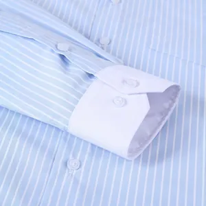 Dettaglio di camicia da uomo a righe blu con polsini bianchi e bottoni a contrasto