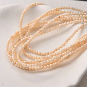 Close-up macro detail of 3mm natural freshwater shell round beads for DIY jewelry making.