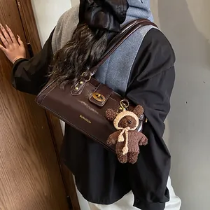 Bolso baguette de cuero brillante marrón con un encanto de oso para mujer